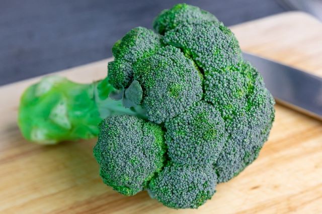 Whole Broccoli on Cutting Board